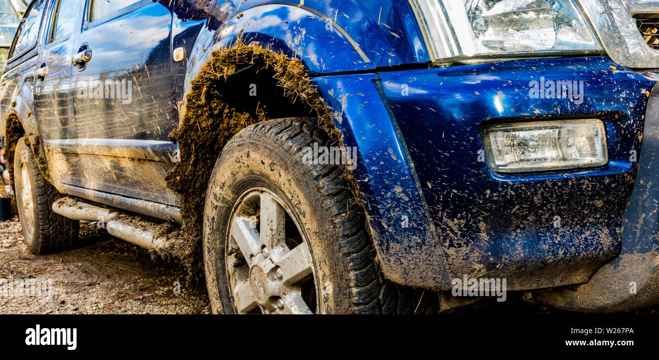 Dirty Isuzu Rodeo blu 4X4 off roader SUV intonacato con fango su un vialetto Foto Stock