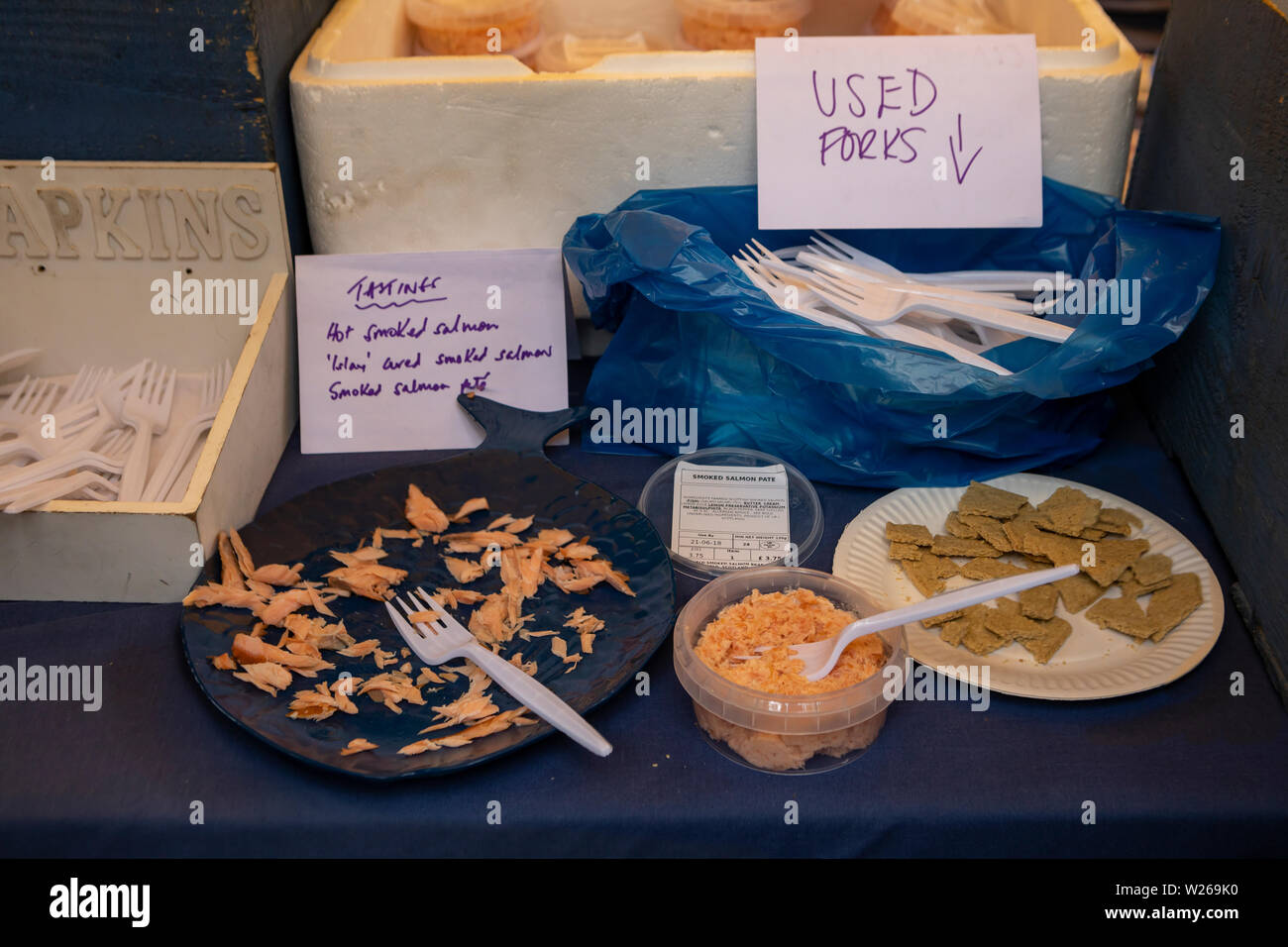 Supporto di mercato con salmone affumicato su piastre di plastica per degustazione presso il mercato a Stockbridge Foto Stock