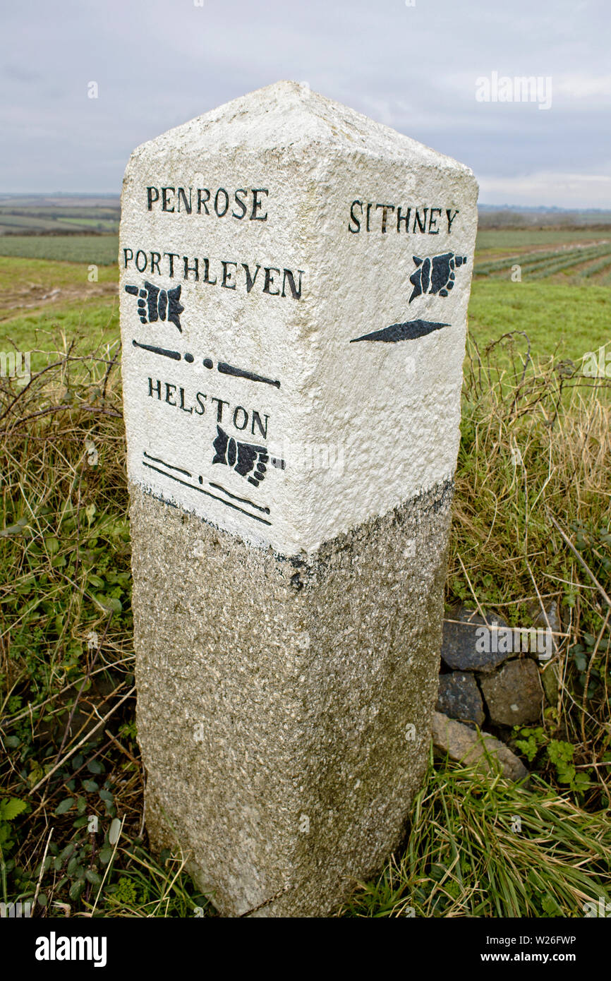 Vecchia pietra miliare in corrispondenza di un incrocio stradale tra Helston e Porthleven, Cornwall, Inghilterra, Regno Unito. Foto Stock
