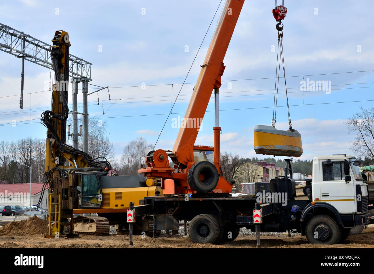 Pali di fondazione macchina perforatrice e gru mobile sulla costruzione cite su ferrovia Foto Stock