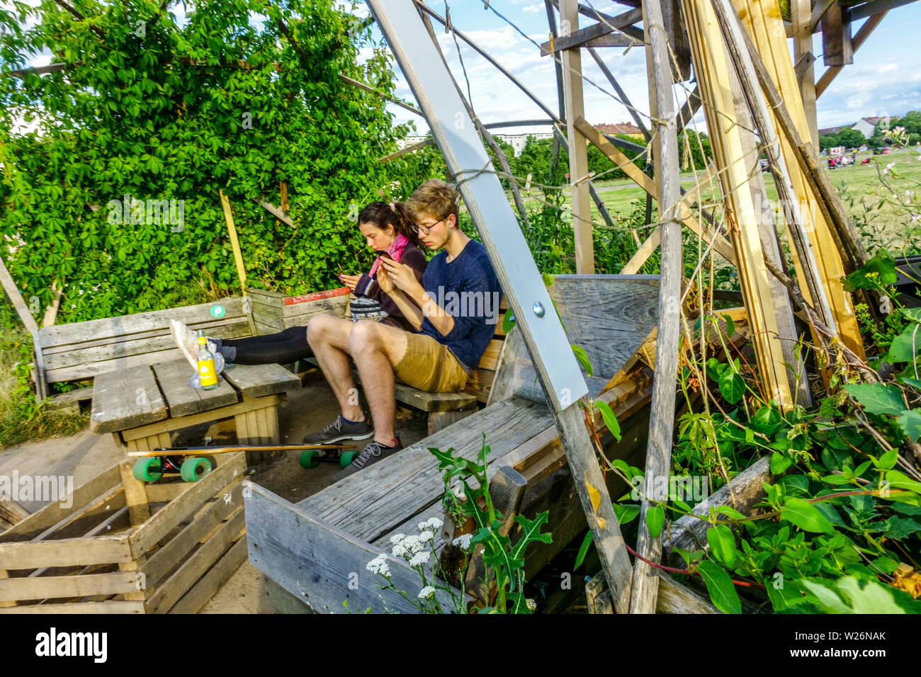 Una giovane coppia, la gente gode di piacere nel giardino della comunità sul campo Tempelhof, Berlino-Neukölln, Germania vita quotidiana Europa Foto Stock