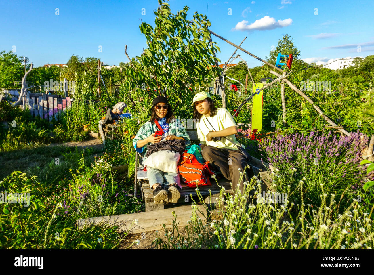 Due ragazze di Bangkok, Tailandia, che si godono nel giardino della comunità di Berlino sul campo Tempelhof, Berlino-Neukölln, Germania People Europe Foto Stock