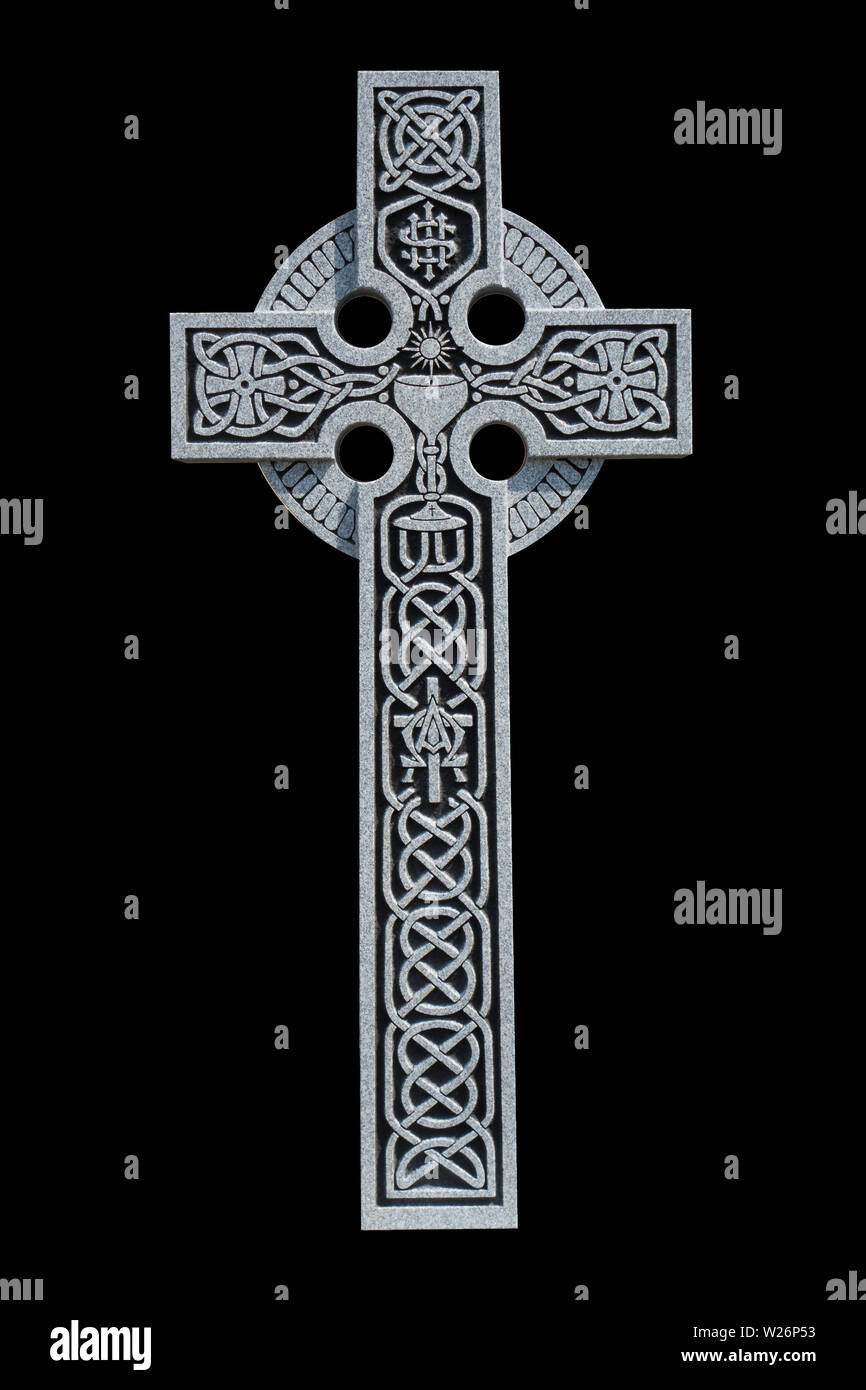Un raffinato granito croce celtica dalla tomba di un prete cattolico, che mostra il nodo celtico pattern, una comunione calice e il simbolo IHS Foto Stock