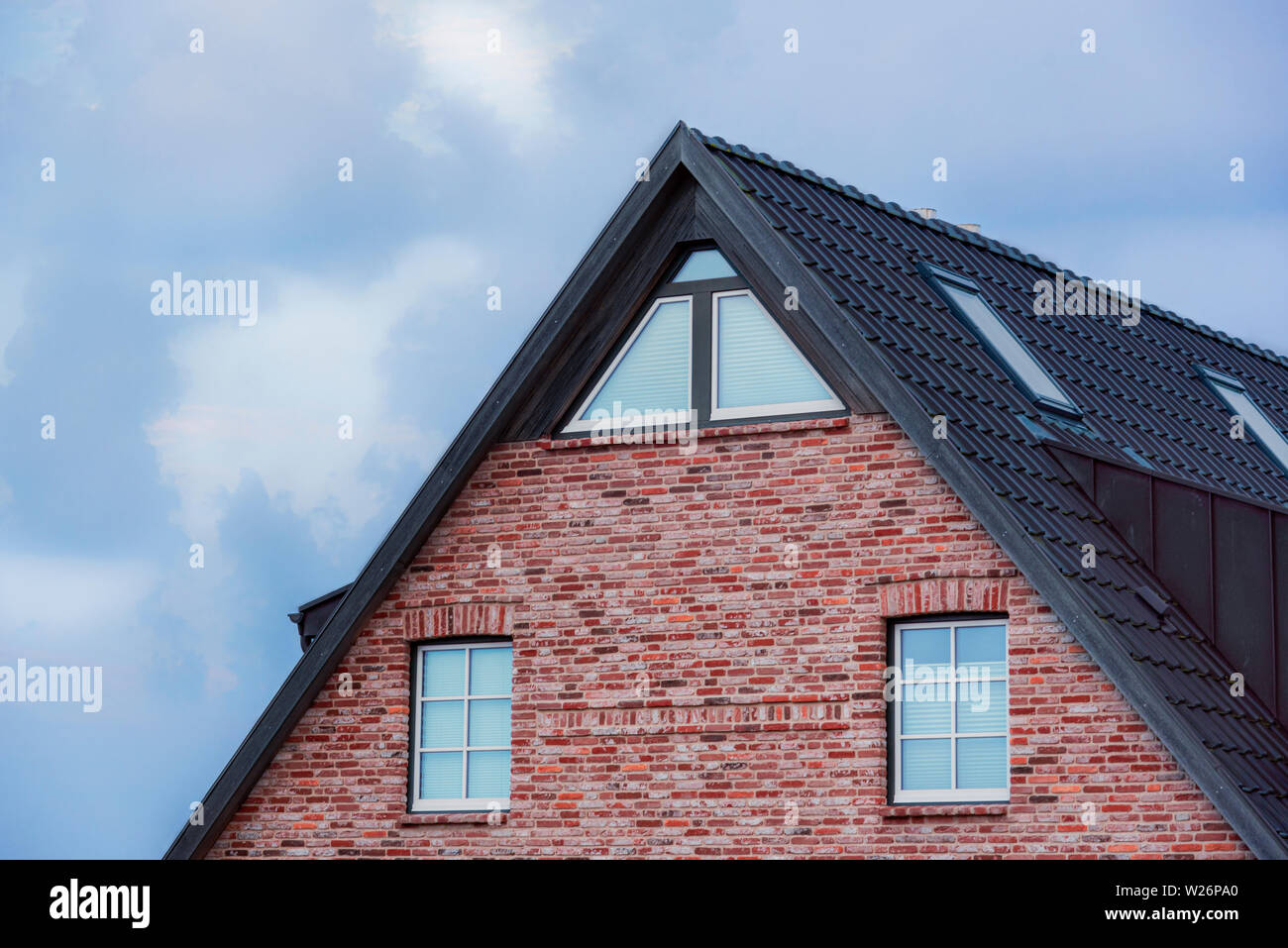 Tradizionale casa frisone sull'isola di Sylt, Germania nel mare di Wadden. Rosso-muro in mattoni con piastrelle nere tetto Foto Stock