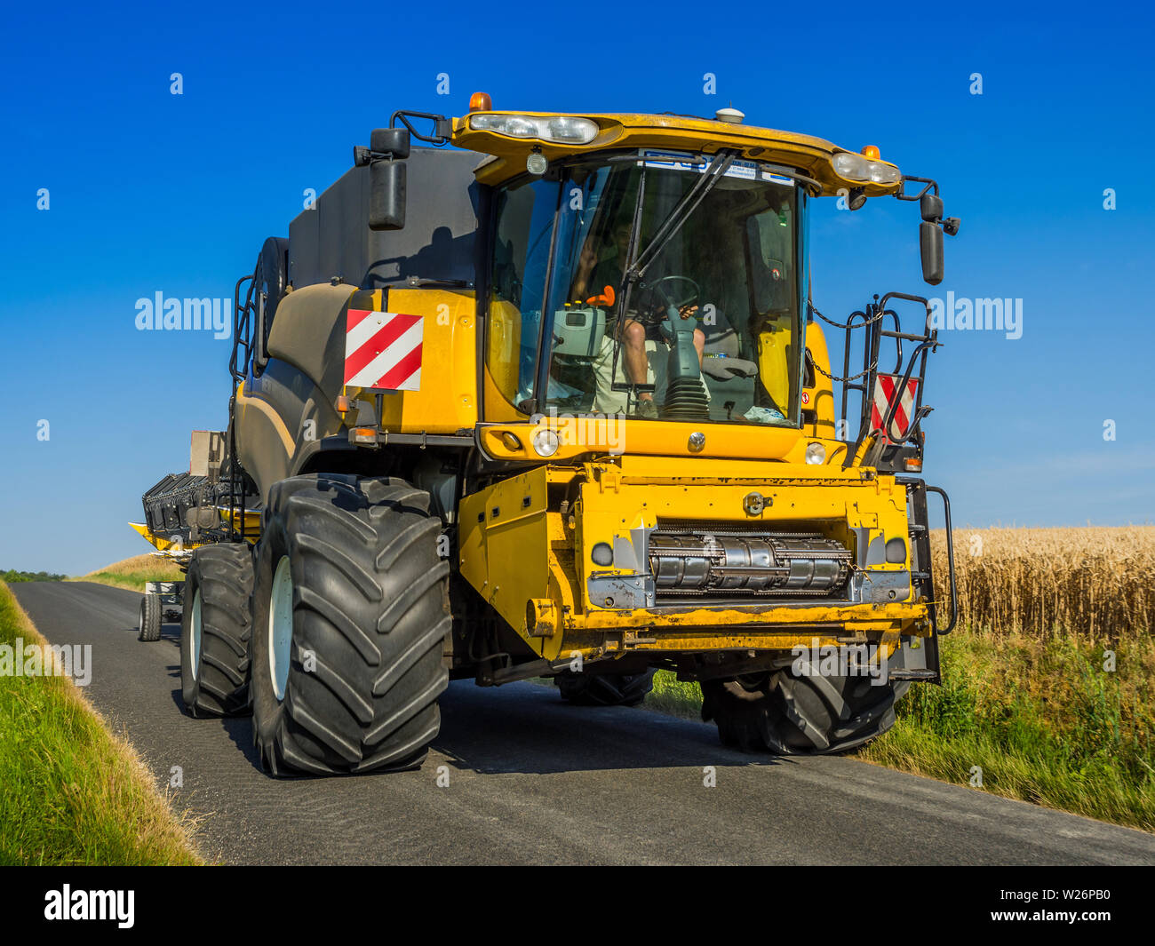 New Holland mietitrebbia su strada pubblica - Francia. Foto Stock