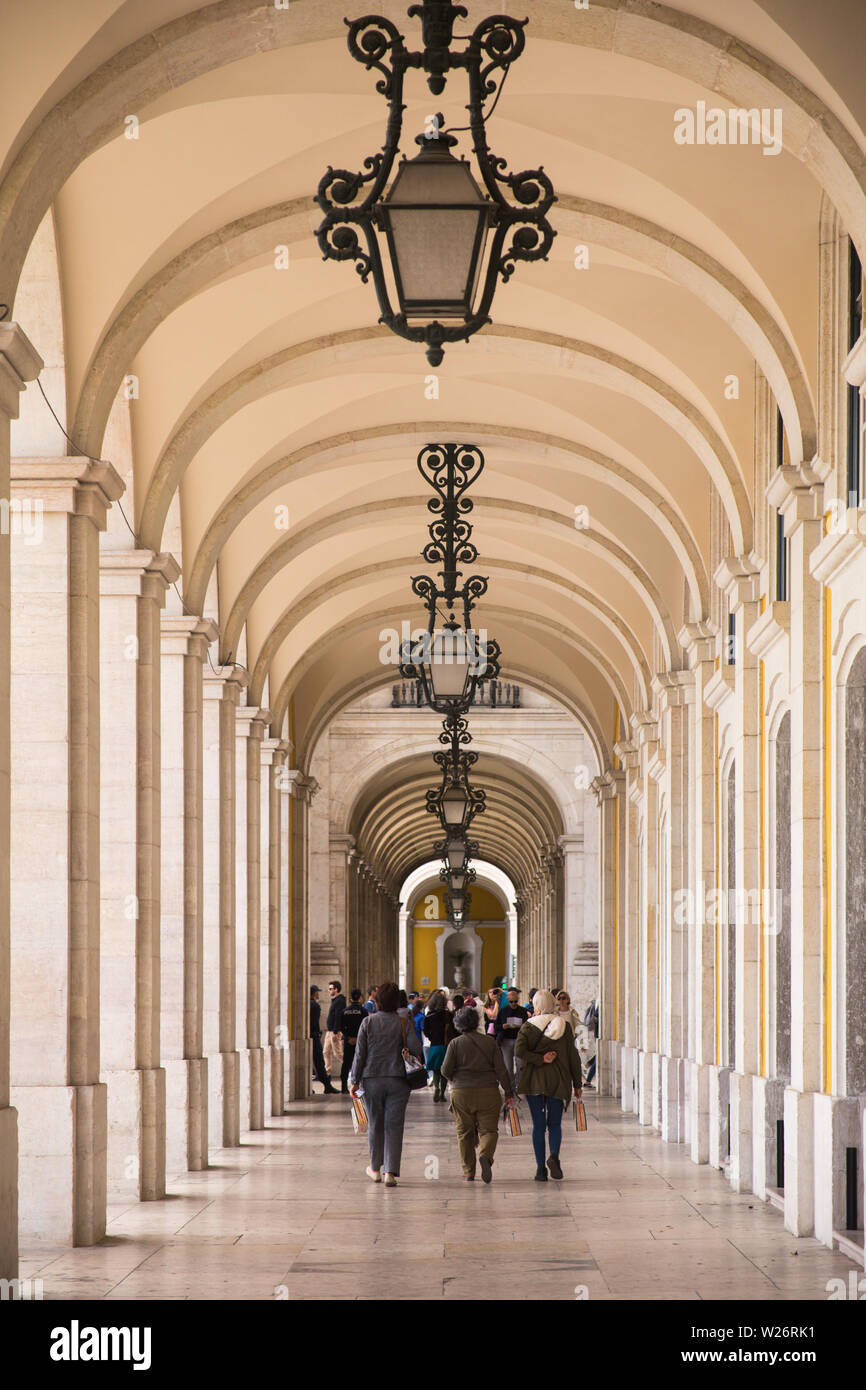 I pedoni a piedi l'impressionante galleria che ospita la passerella sotto gli edifici del governo presso l'Arco de Rua Augusta off la Praça do Comércio, Lisbona, Portogallo Foto Stock
