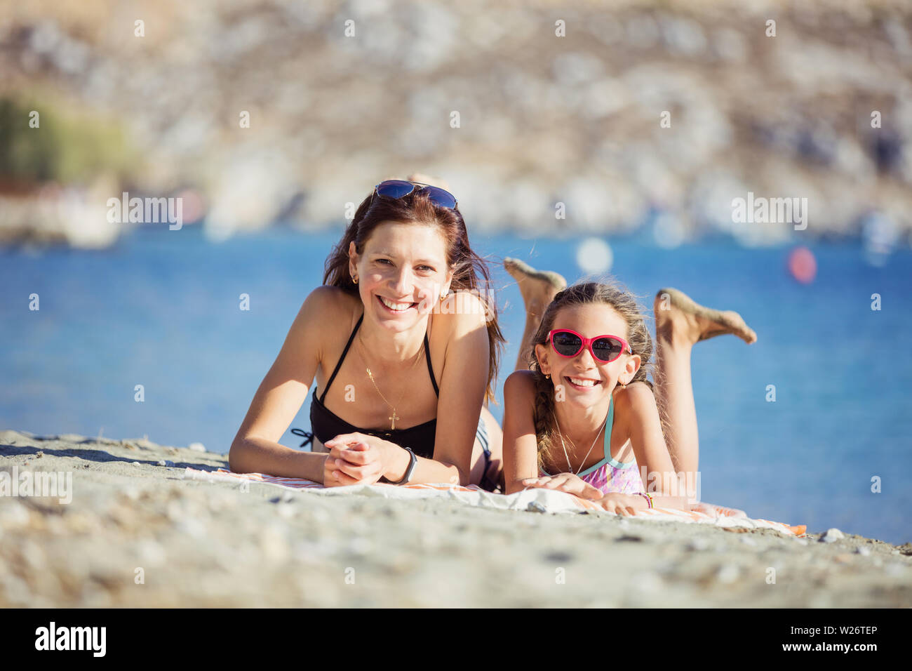 Bella giovane donna e sua figlia godendo di giorno di estate sulla spiaggia Foto Stock