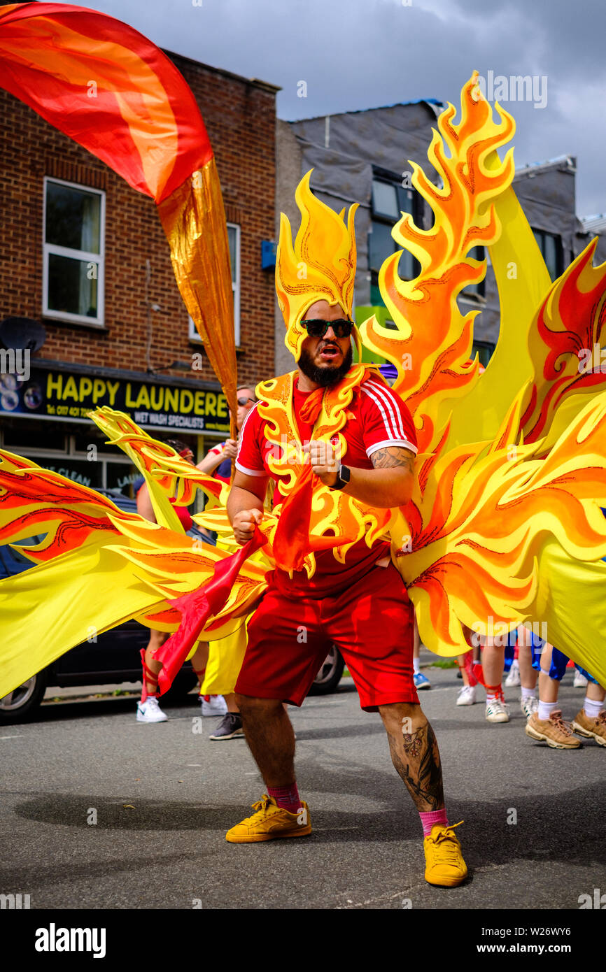 Un esecutore maschio vestito in un vivacemente colorato costume di fiamma  dancing in parata a St Pauls Carnevale, Bristol, 6 Luglio 2019 Foto stock -  Alamy