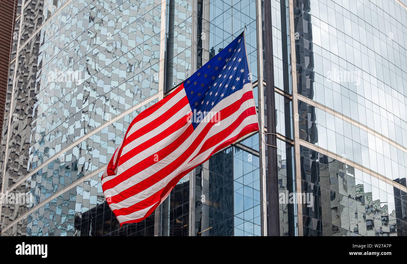 USA il simbolo. Bandiera americana sventolare in Chicago Downtown. Highrise gass edifici sullo sfondo. Foto Stock