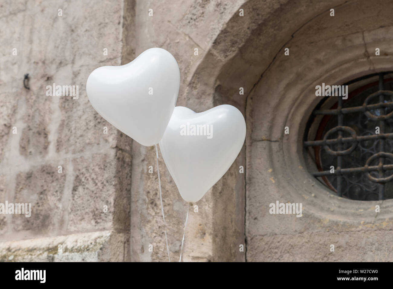 Due bianchi a forma di cuore palloncini Vola di fronte all edificio storico, Germania Foto Stock