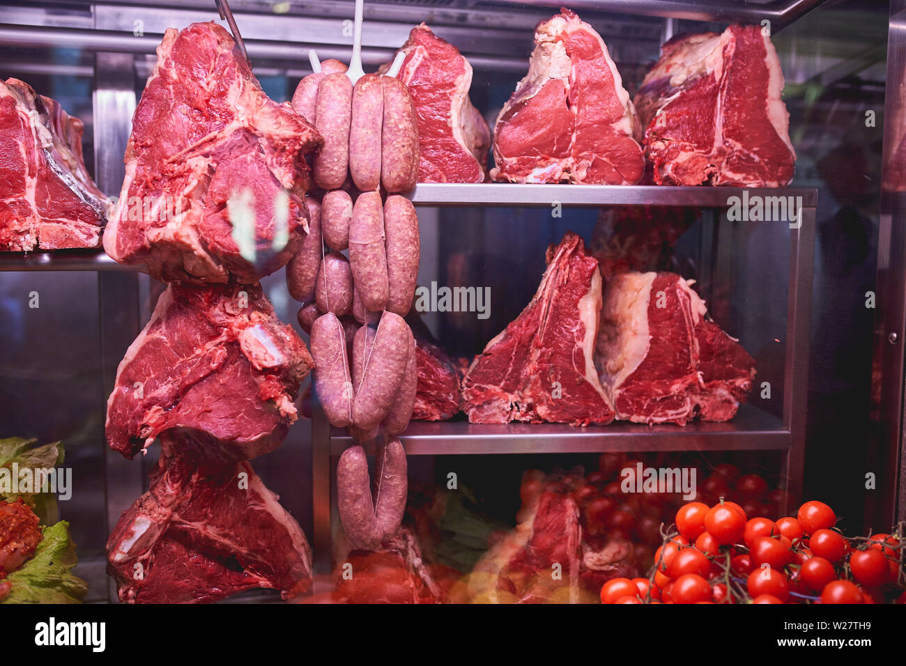 Raw bistecche fiorentine (bistecca alla fiorentina) e salsicce in una tipica trattoria a Firenze (Italia). Formato orizzontale. Concetto di cibo. Foto Stock