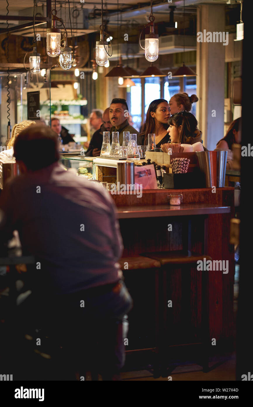 London, Regno Unito - Febbraio, 2019. I giovani aventi un drink in un pub di venerdì sera dopo il lavoro. Foto Stock