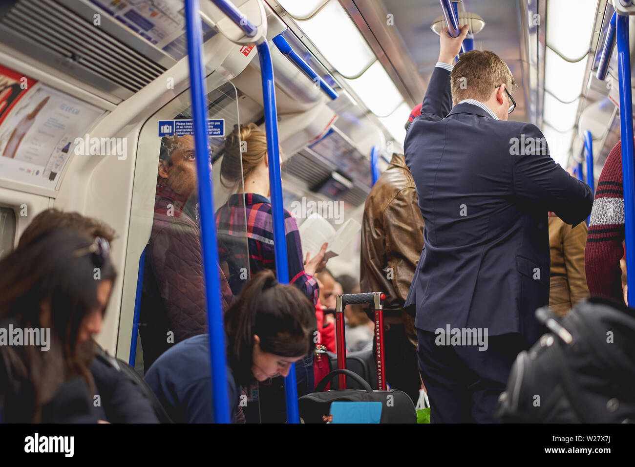 London, Regno Unito - Febbraio, 2019. Persone il pendolarismo su un treno della metropolitana di Londra. Il tubo gestisce fino a 5 milioni di passeggeri al giorno. Foto Stock