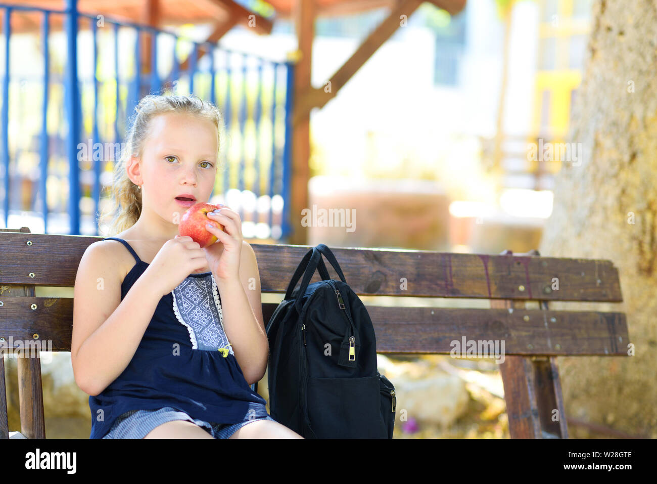 Bambina è una mela. Alimentazione sana. Piuttosto bambino mangiare un Apple presso il Park , natura all'esterno. Adolescente pupilla godendo di un sano pranzo in schoolyard. Foto Stock