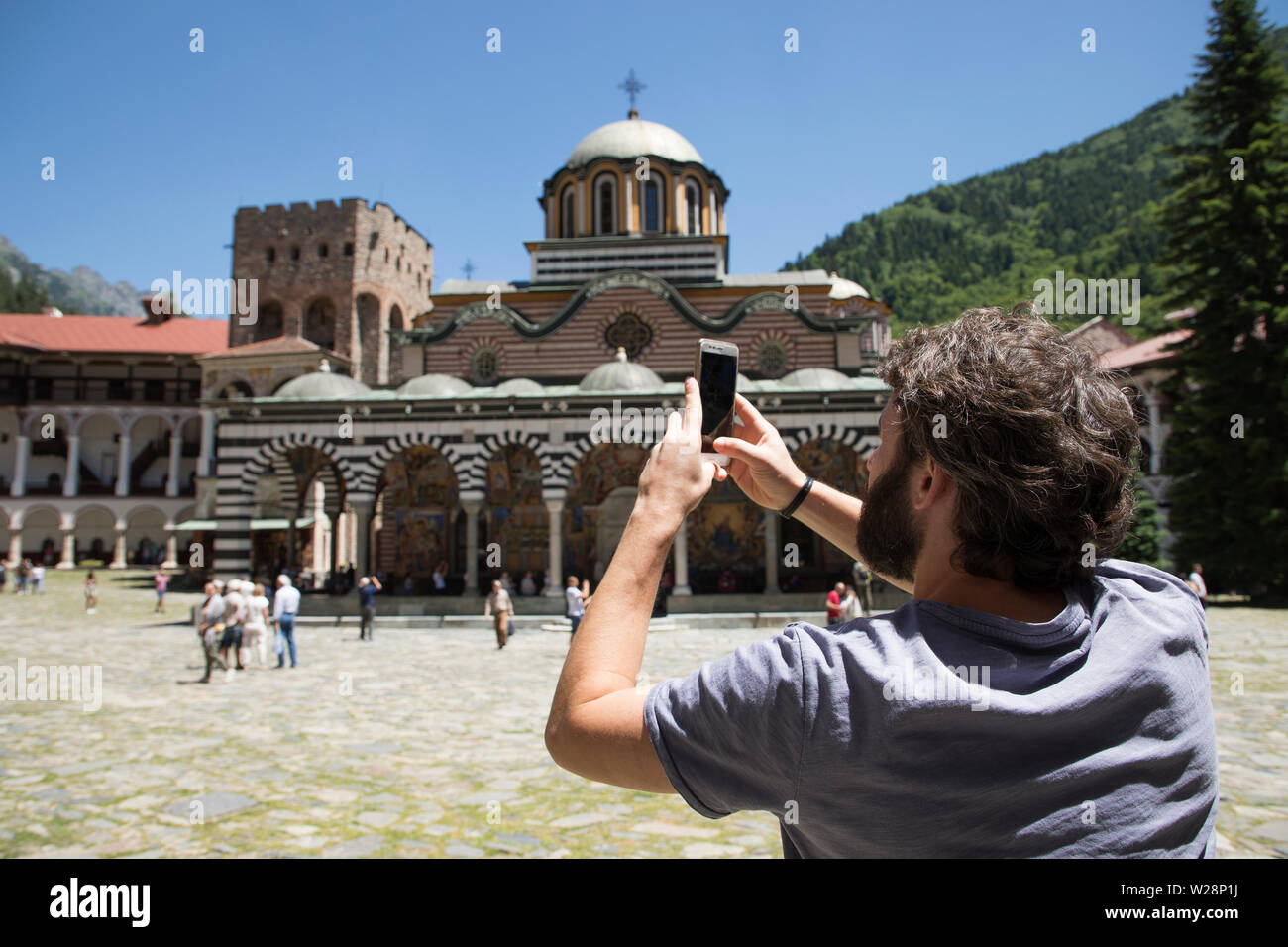 Il monastero di Rila, Bulgaria - Luglio 06, 2019: la chiesa ortodossa orientale sul Monastero di Rila motivi, il più grande della Bulgaria. Un uomo è fotografare t Foto Stock