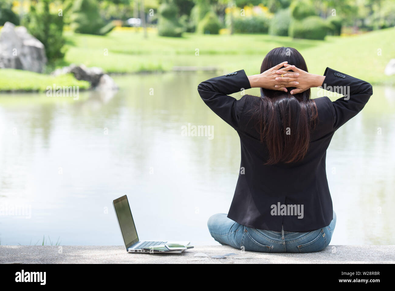 Grave business donna lavorare sodo e con un grave problema in un parco pubblico. Lavorando su laptop all'esterno. Immagine ritagliata femminile di lavorare sul computer portatile mentre si Foto Stock