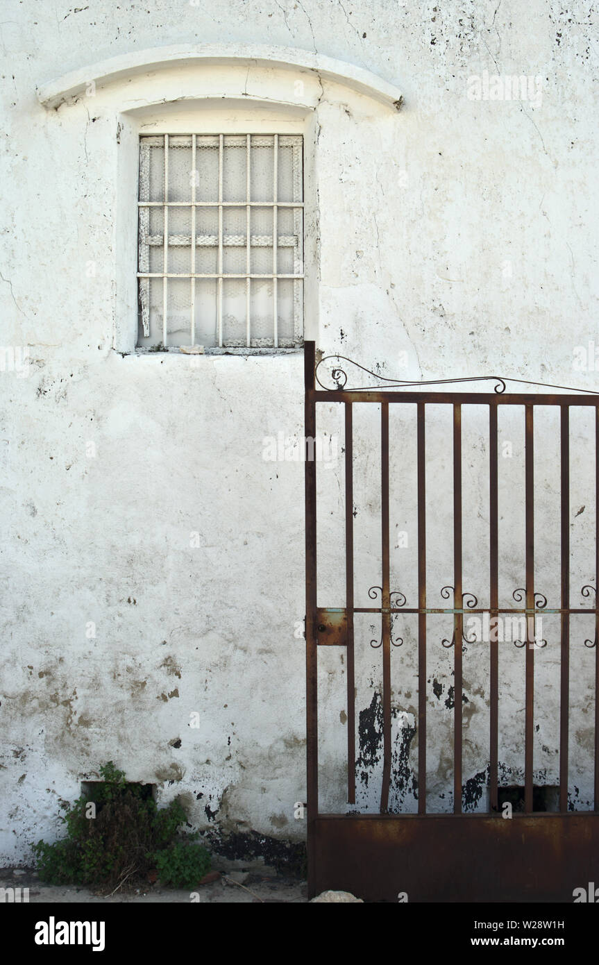 Il vecchio muro bianco con finestra con vernice deteriorata Foto Stock