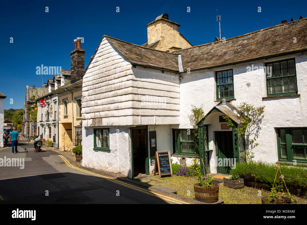 Regno Unito, Cumbria, Hawkshead, Main Street, il National Trust bookshop in vecchio dipinto di ardesia proprietà appesi Foto Stock