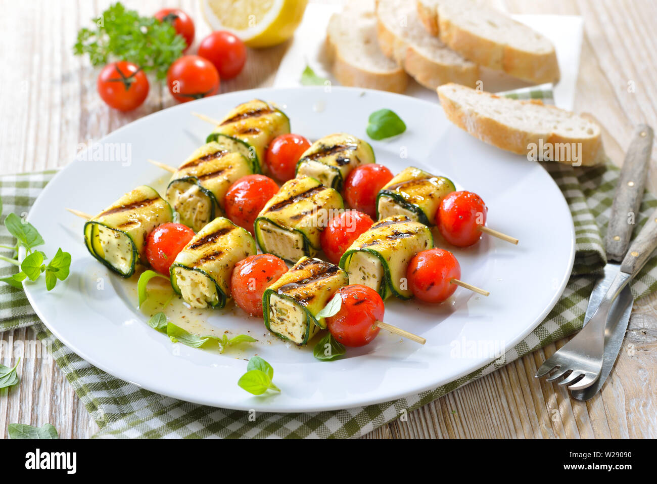 Pasto vegetariano: alla griglia marinati spiedini di feta con formaggio greco, zucchine, pomodori ciliegia e erbe aromatiche Foto Stock