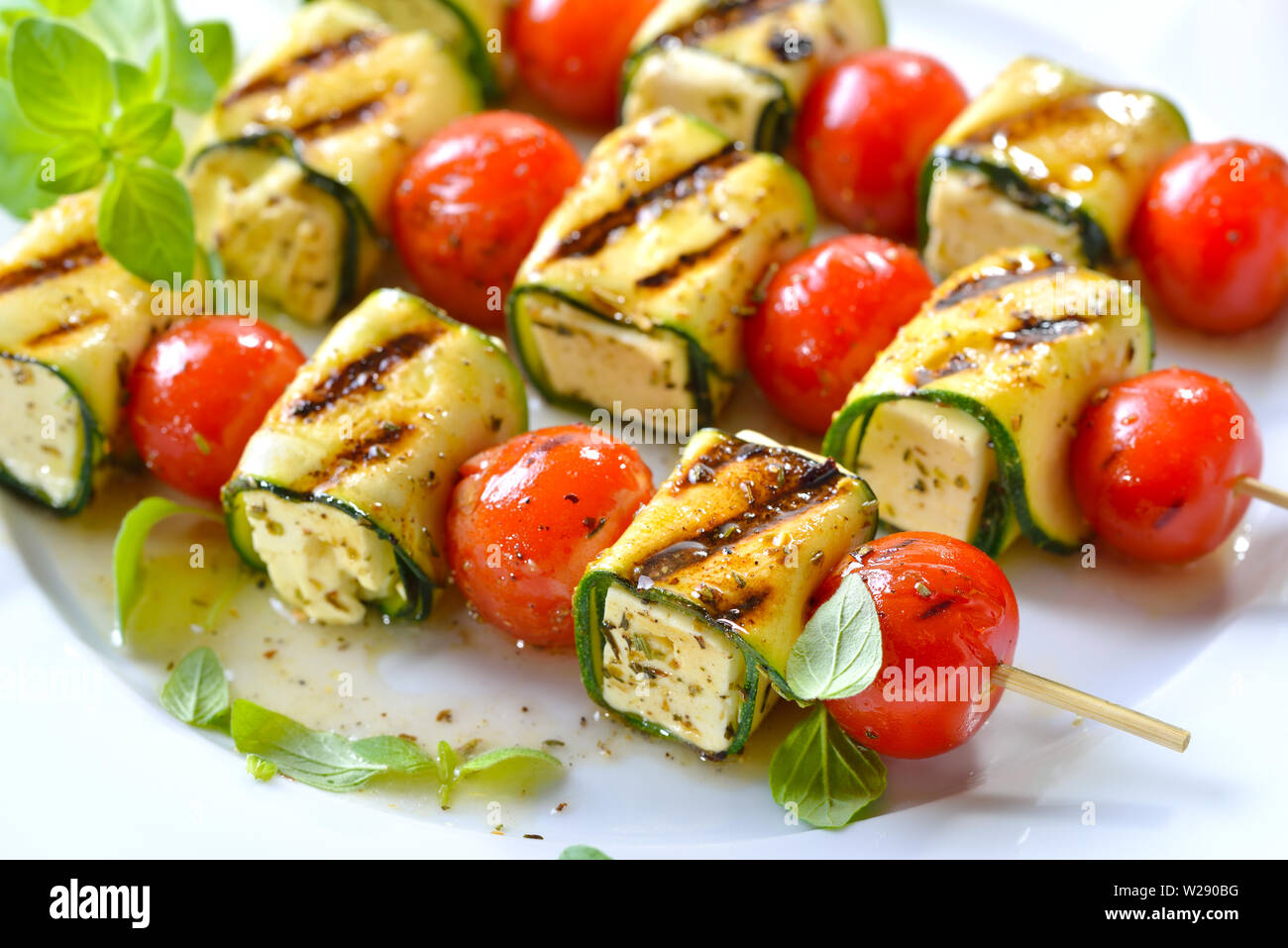 Pasto vegetariano: alla griglia marinati spiedini di feta con formaggio greco, zucchine, pomodori ciliegia e erbe aromatiche Foto Stock