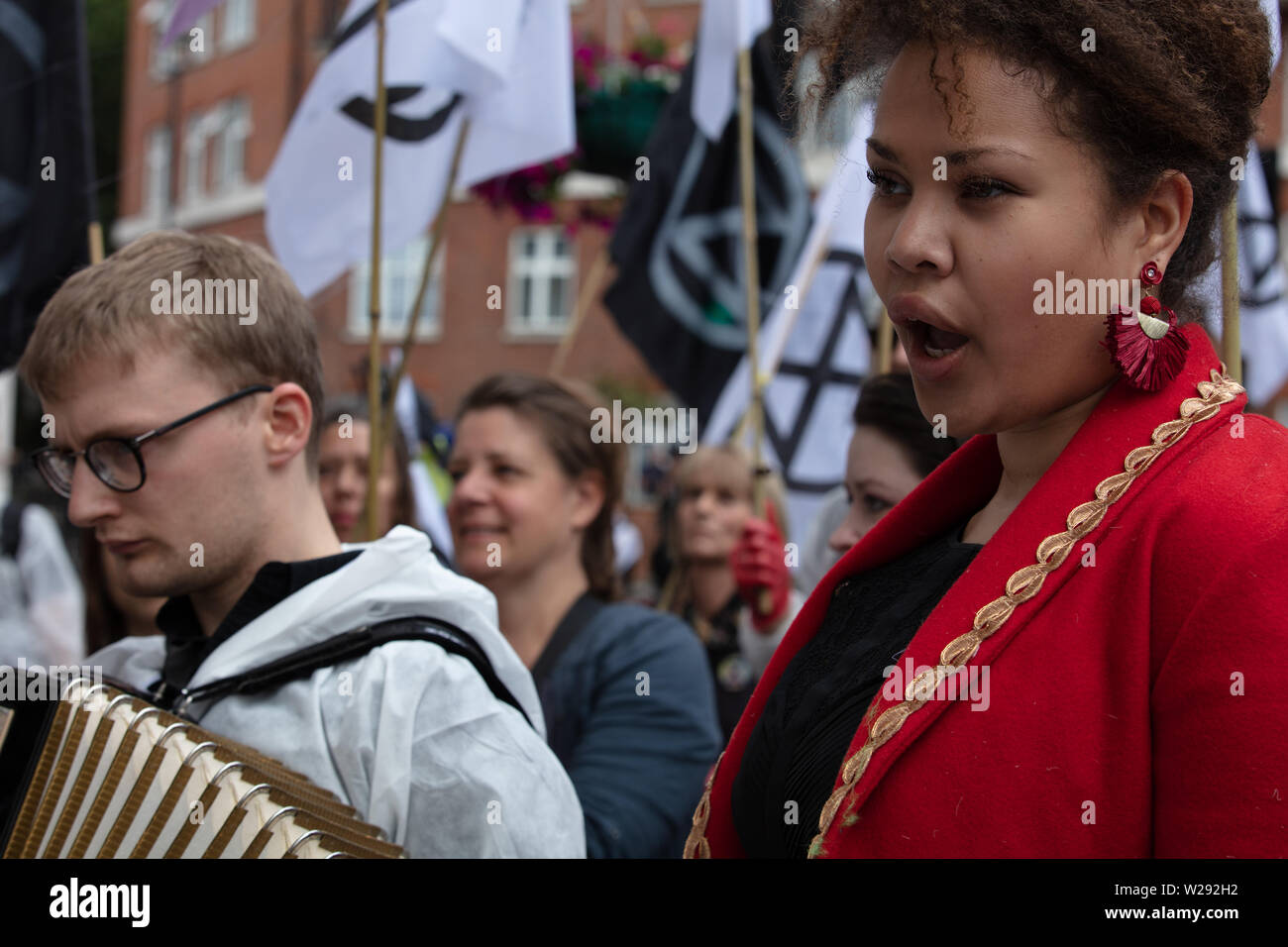 Londra, Regno Unito. Il 2 luglio 2019. La Ribellione di estinzione delle arti e della cultura gruppo per creare una processione silenziosa di teatro e di fronte a diversi combustibili fossili aziende. La protesta del gioco è basato su Bizet opera Carmen, con la vita reale di attori e un cantante di opera. Nella foto: la cantante lirica Ibbett-Brown Simone canta una canzone dall'opera Carmen durante la protesta, il testo adattato per l'occasione. Credito: Joe Kuis / Alamy News Foto Stock