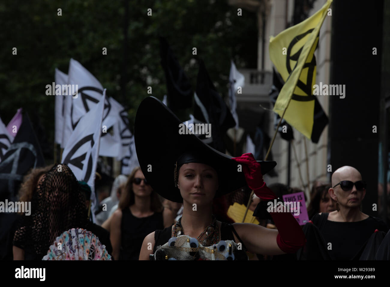 Londra, Regno Unito. Il 2 luglio 2019. La Ribellione di estinzione delle arti e della cultura gruppo per creare una processione silenziosa di teatro e di fronte a diversi combustibili fossili aziende. La protesta del gioco è basato su Bizet opera Carmen, con la vita reale di attori e un cantante di opera. Nella foto: Processione con Carmen, vestita di nero con un lungo velo nero, che rappresenta lo sporco di olio. Credito: Joe Kuis / Alamy News Foto Stock