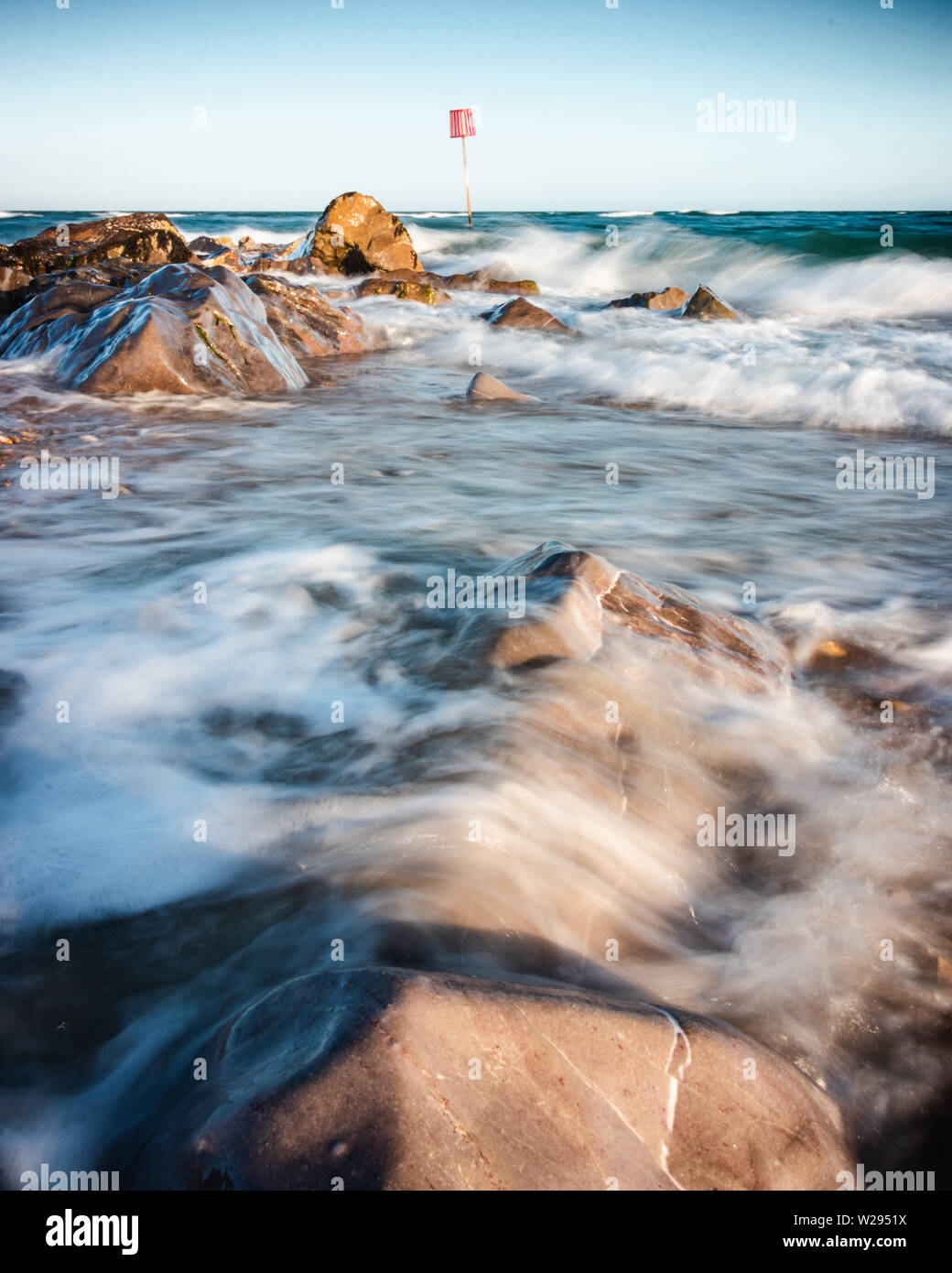 Il lavaggio delle onde sulle rocce in riva al mare Foto Stock