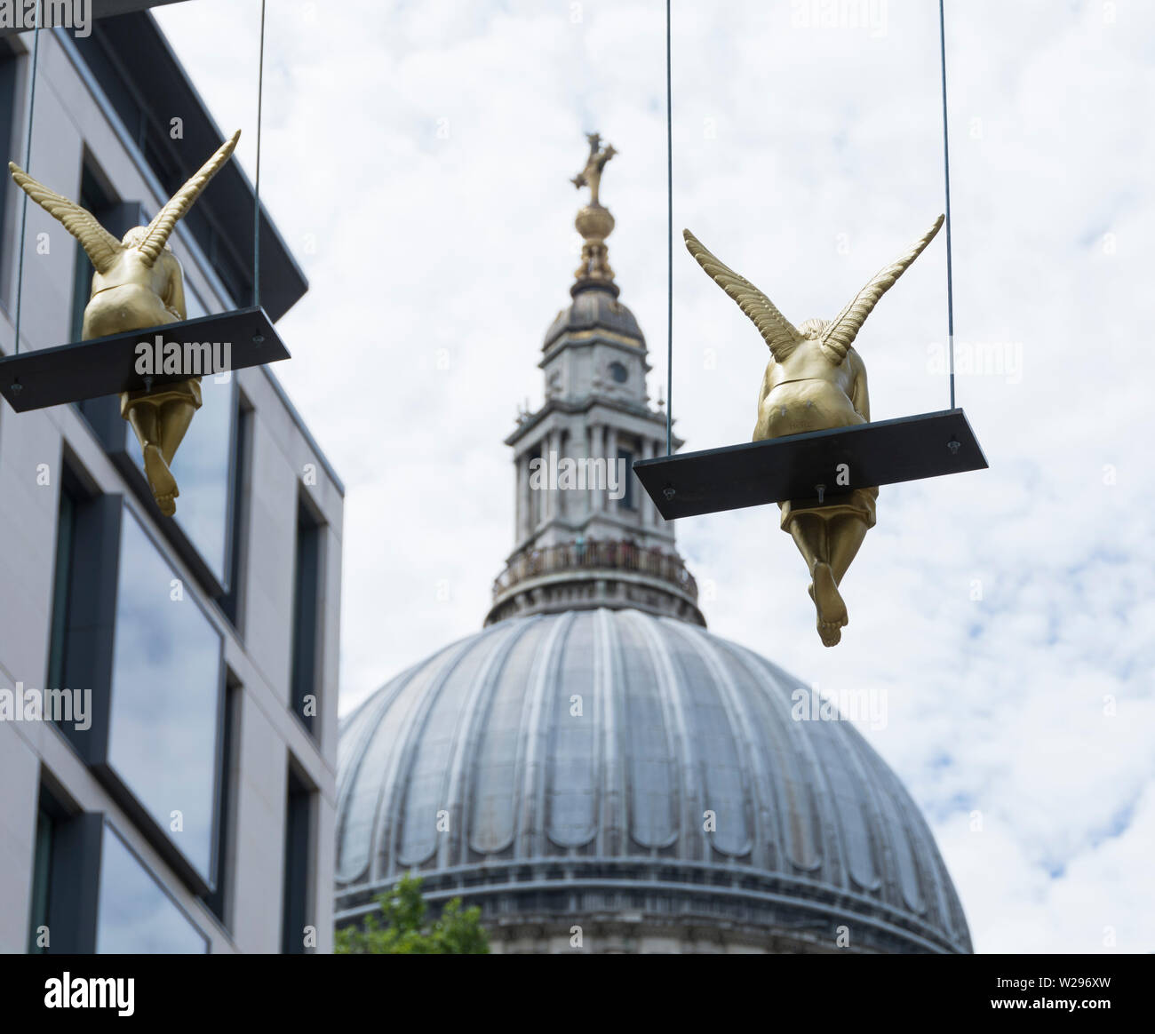 Pausa pranzo installazione da KHBT e Ottmar Horl - 40 Golden Angeli in appoggio sulle altalene fuori dalla cattedrale di St Paul, Londra, Regno Unito Foto Stock
