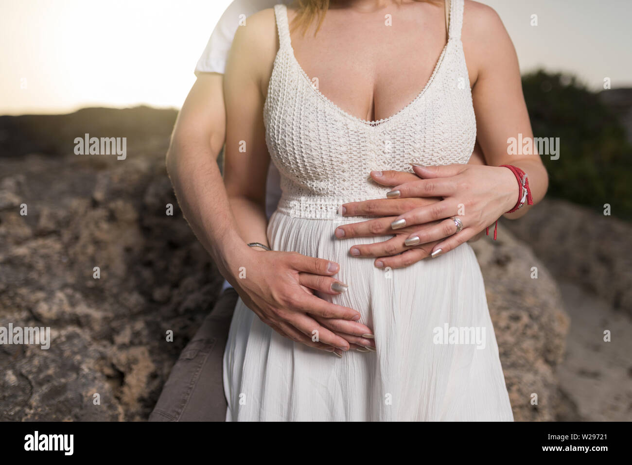 Uomo con la pancia di sua moglie incinta. Donna incinta e amorevole marito  abbracciando la pancia sulla spiaggia Foto stock - Alamy