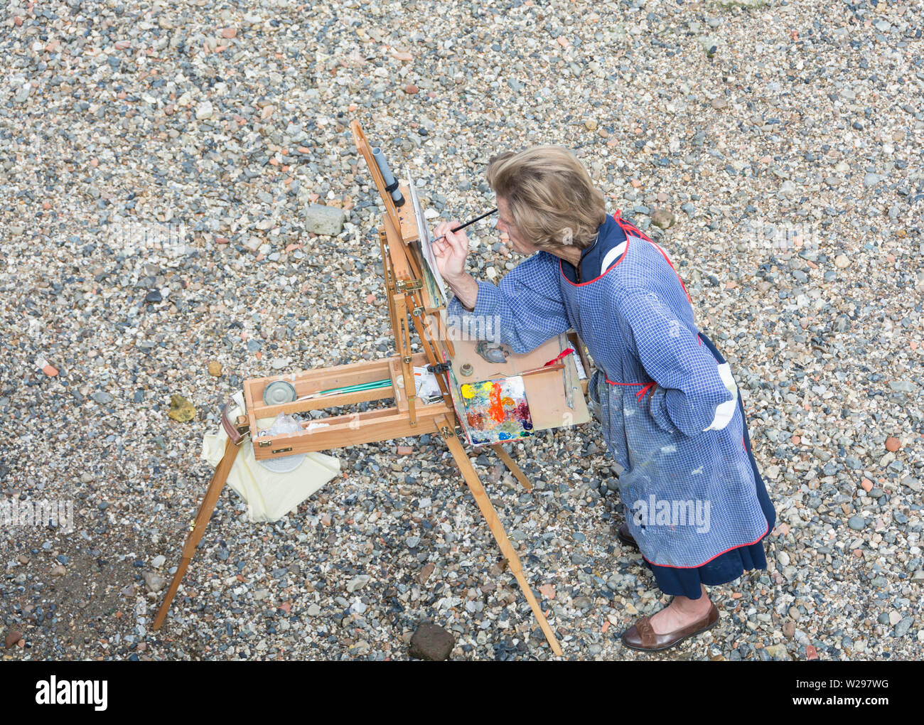 Artista al lavoro - Pittura di classe sul Tamigi foreshore, di fronte alla galleria Tate Modern a Bankside, London, Regno Unito Foto Stock