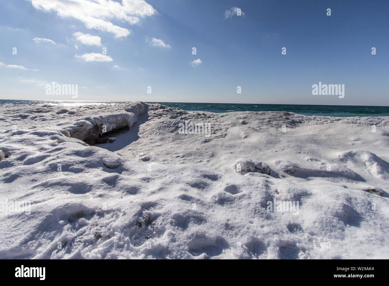 Giornata invernale in spiaggia. Cumulo di neve e ghiaccio accumulato sulla costa del lago Michigan a Sleeping Bear Dunes National Lakeshore nel Michigan. Foto Stock