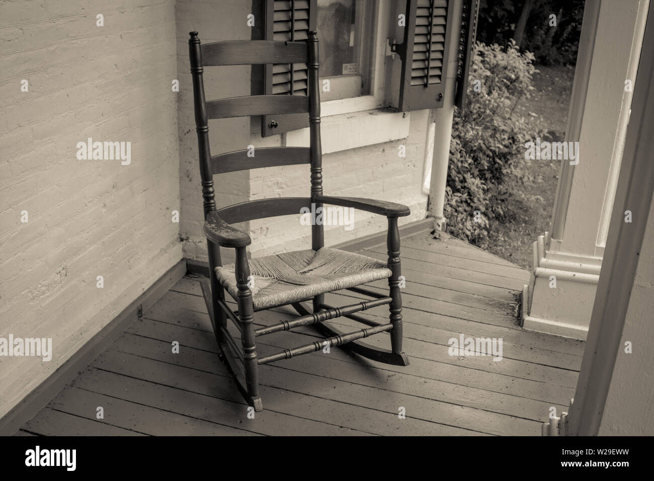 Svuotare la sedia a dondolo. Vuoto sedia a dondolo sotto il portico di casa in stile retrò Foto Stock