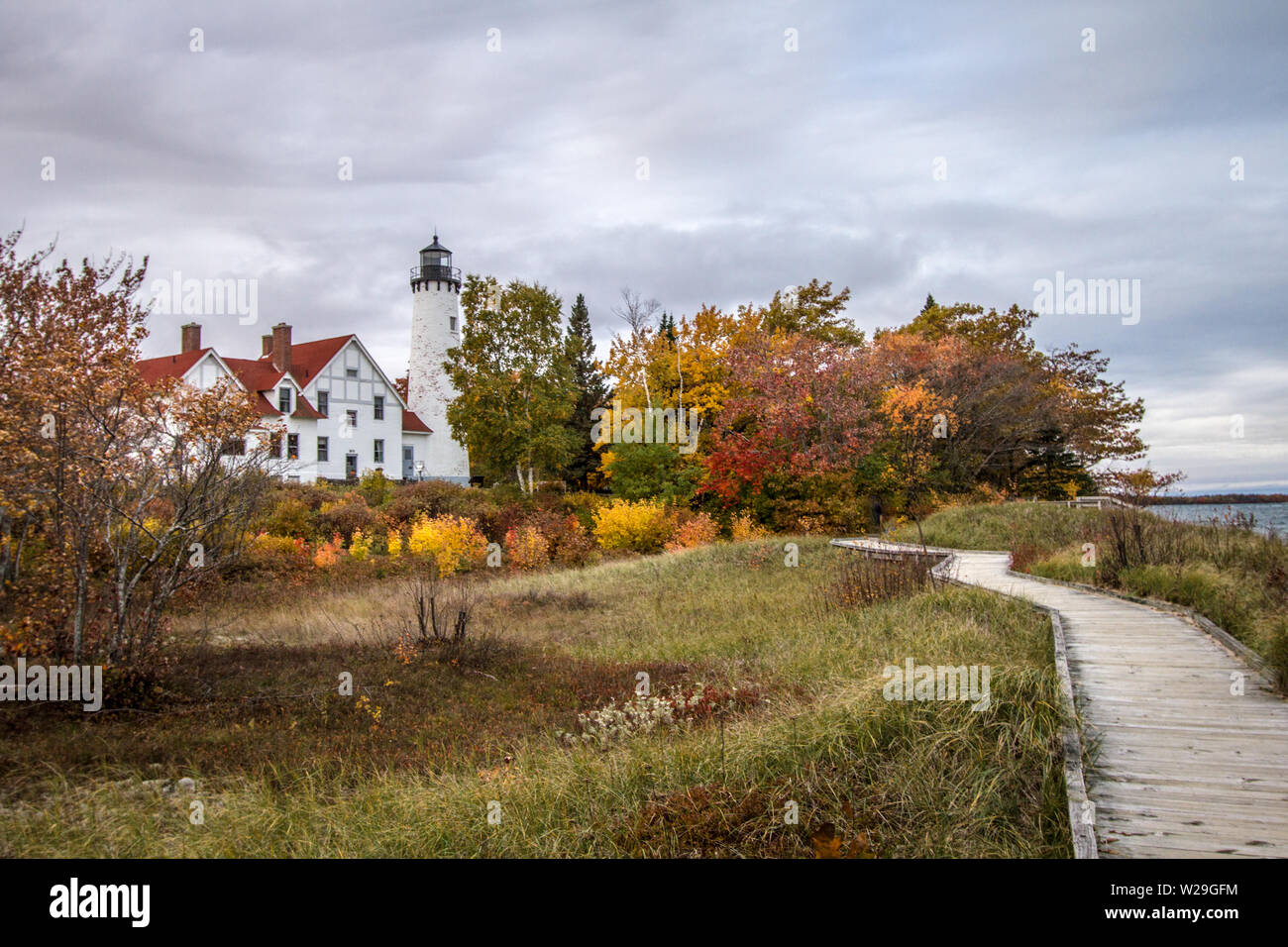 Autunno Michigan paesaggio. Il Boardwalk Trail sulla costa del lago Superior con il punto Iroquois Lighthouse circondato da vivaci colori dell autunno. Foto Stock