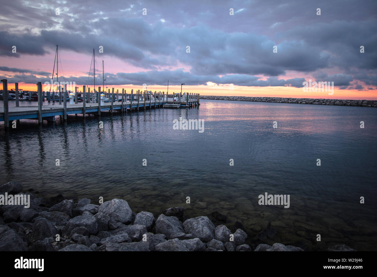 Barca a vela al tramonto sullo sfondo del cielo.. Michigan marina lungo la Great Lakes costa con un bel Cielo di tramonto. Cheboygan, Michigan Foto Stock