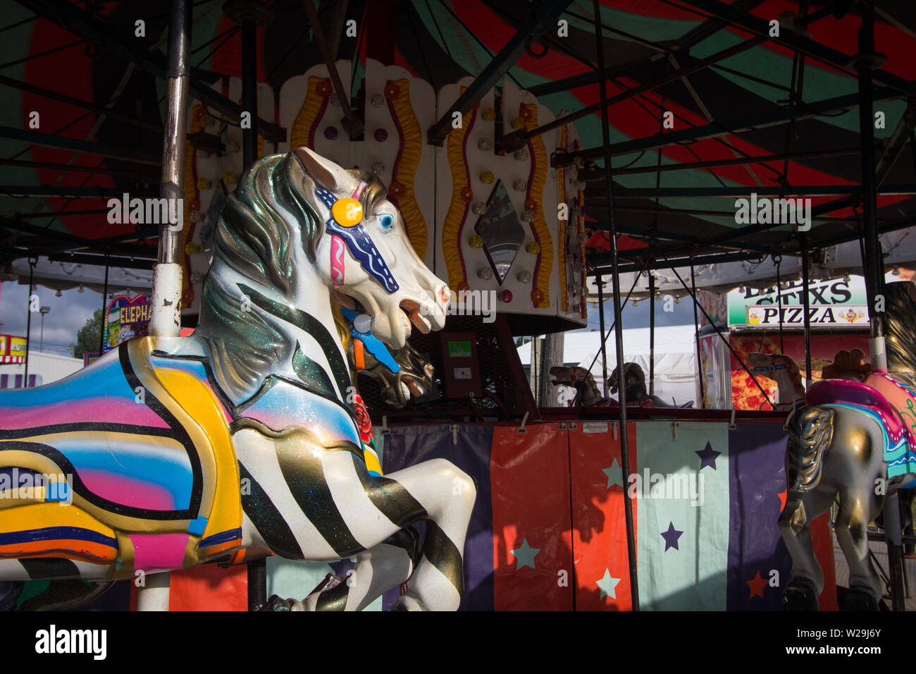 Cheboygan, Michigan, Stati Uniti d'America - 9 Agosto 2018: Close up di coloratissimi Giostra cavalli sul Merry Go Round a Cheboygan County Fair Foto Stock