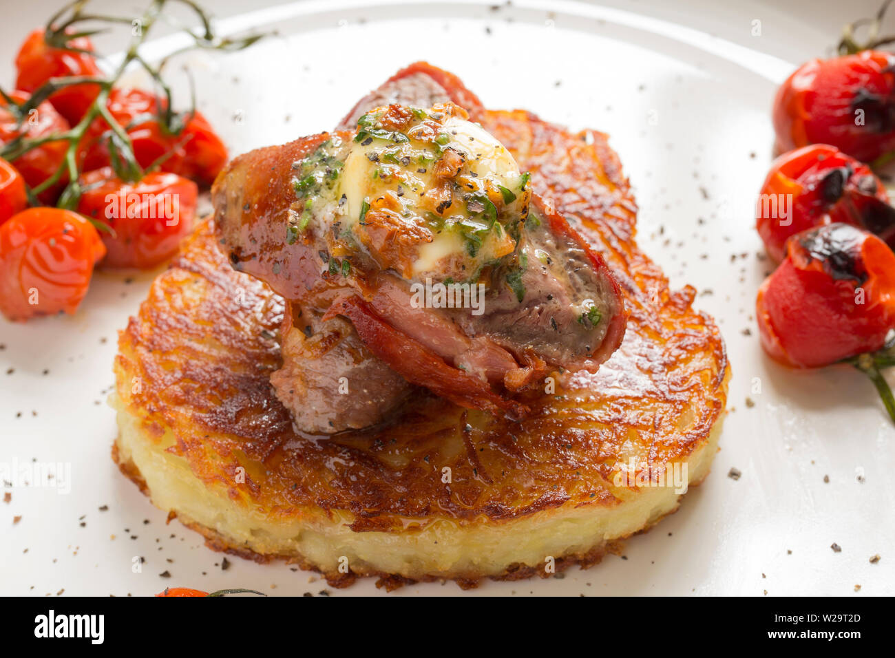 In casa di un piatto di carne di cervo comprendente di capriolo sella filetto, o dorsalino, che è stata avvolta in spagnolo il prosciutto Serrano e fritto flash in modo che rimanga r Foto Stock