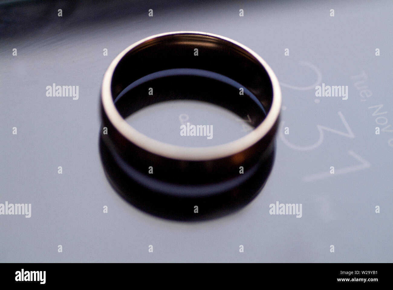 Il impegnato un anello di fidanzamento si siede in cima a un cellulare di visualizzazione di data e ora. Foto Stock