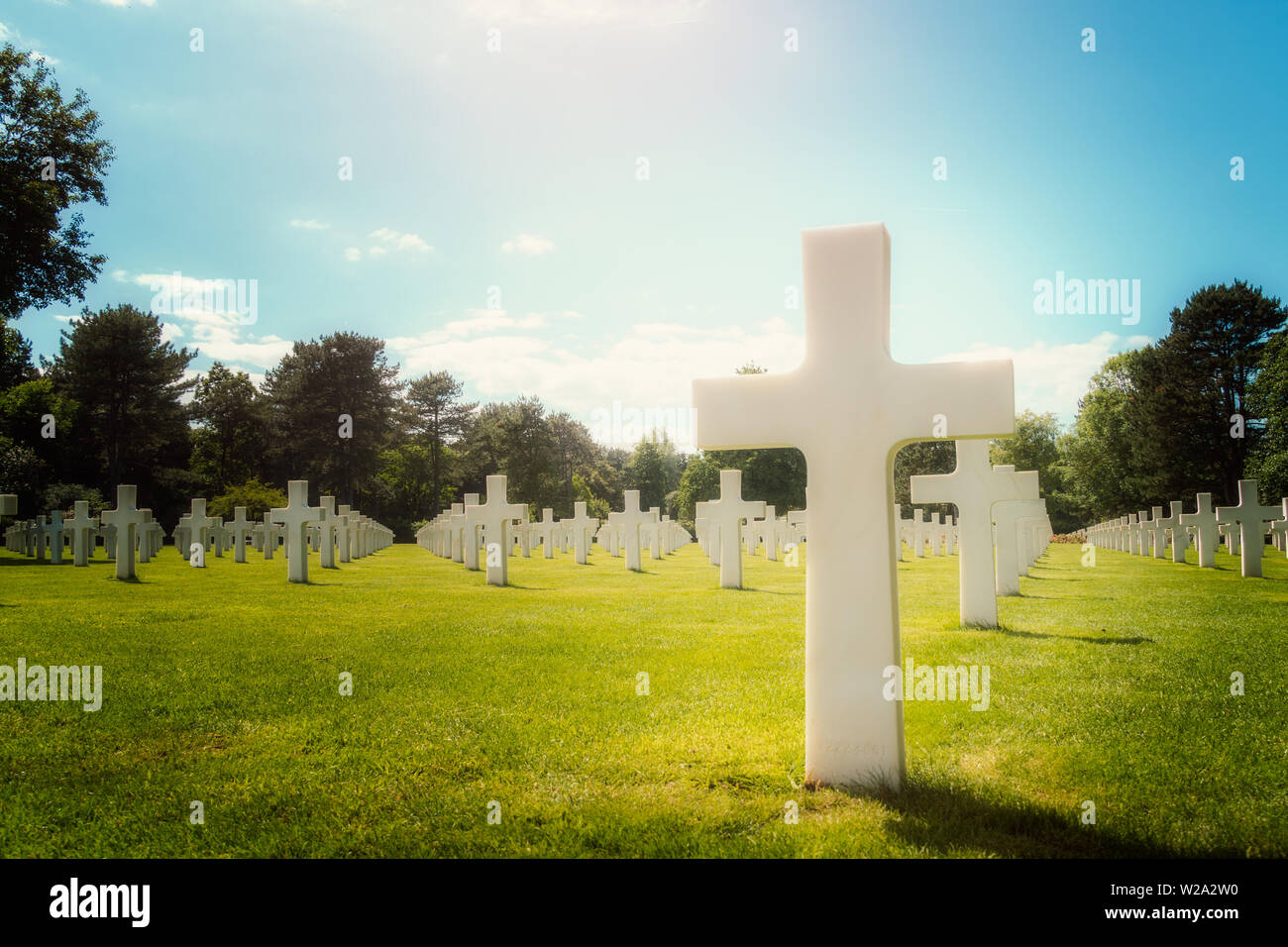 Primo piano di una croce bianca tomba militare in Normandia Cimitero Americano in una giornata di sole, Colleville-sur-Mer, Francia. Con copia spazio. Foto Stock