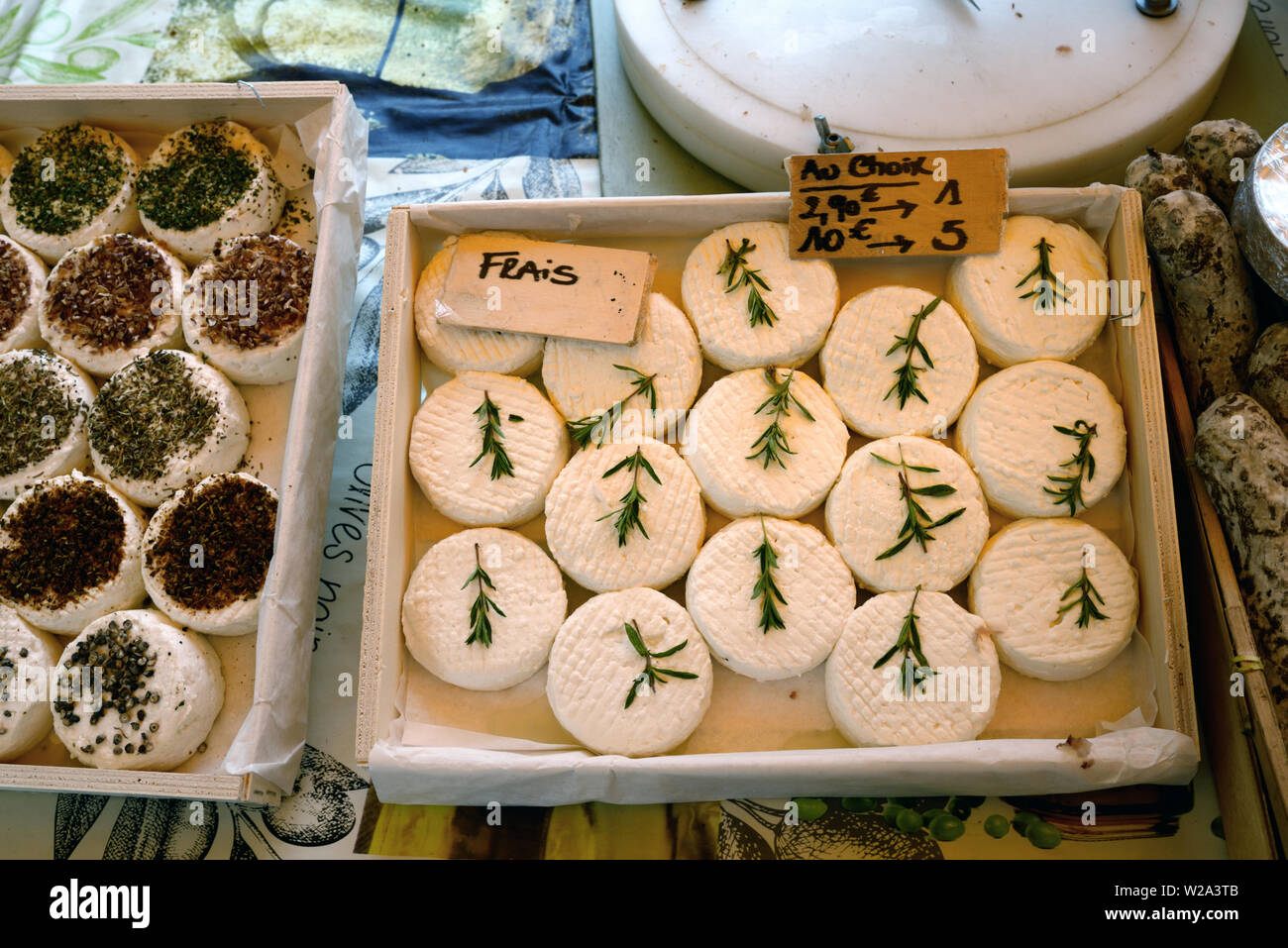 Visualizzazione di fresco Formaggio di capra o di formaggio di capra decorate con ciuffi di foglie di rosmarino in stallo del mercato Bonnieux Luberon Provence Francia Foto Stock