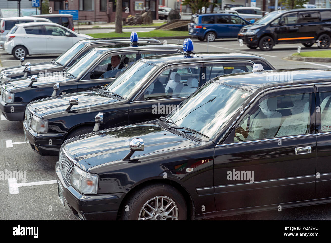 Fila di nero giapponese retrò Taxi Auto. Parcheggio Taxi a Tokyo. I tassisti sono in attesa per i passeggeri. Foto Stock