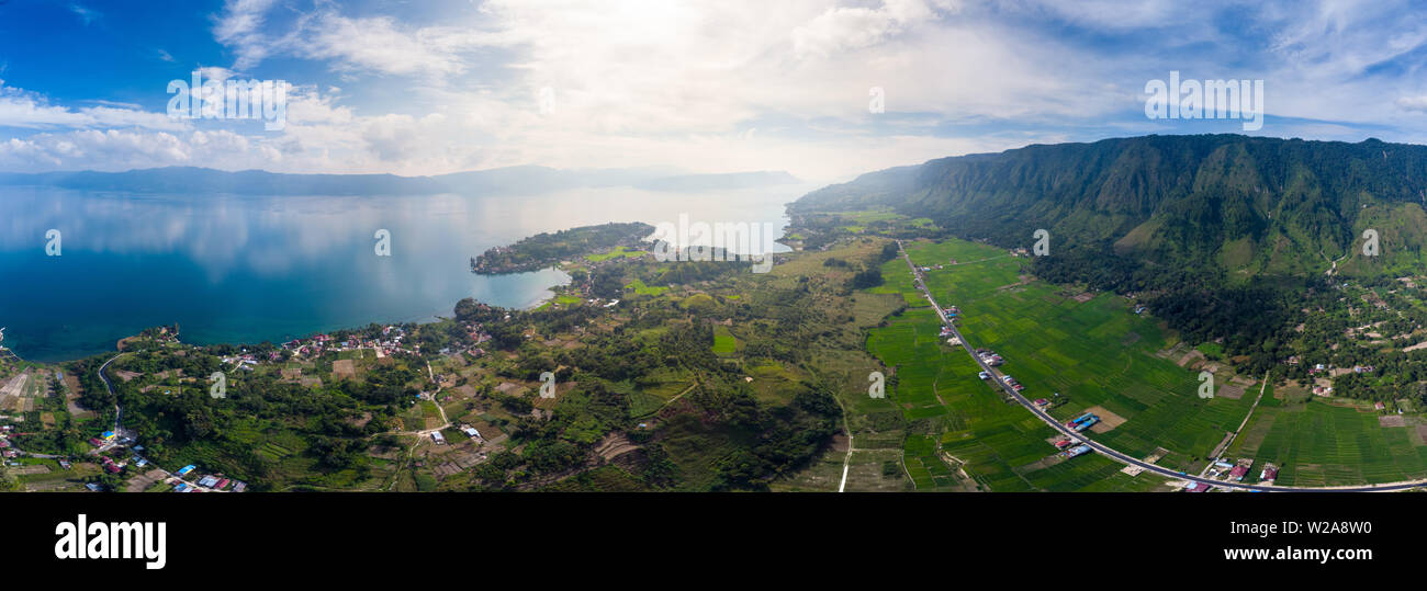 Antenna: Lago Toba e l'isola di Samosir vista dall' alto di Sumatra, Indonesia. Enorme caldera vulcanica coperto da acqua, tradizionali villaggi Batak, riso verde Foto Stock