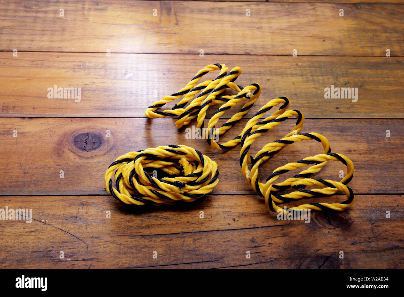 Giallo funi in nylon su sfondo di legno Foto Stock