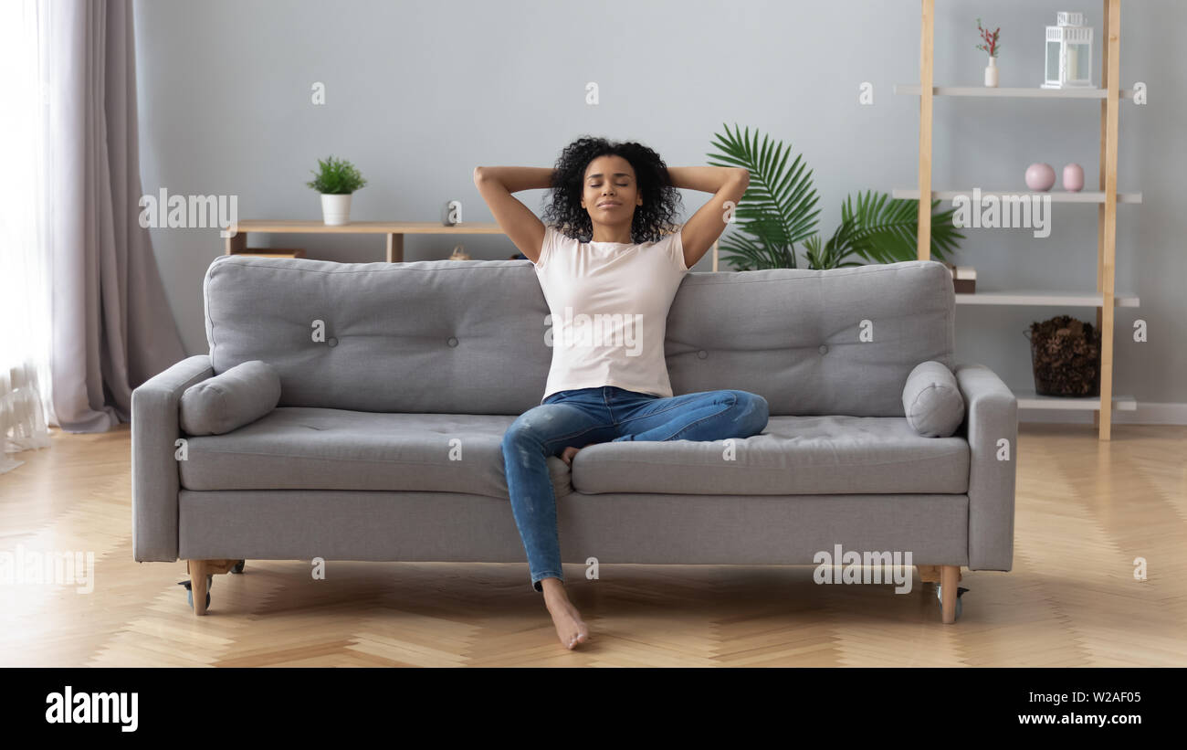 Calma nero donna relax su un comodo divano in soggiorno Foto Stock