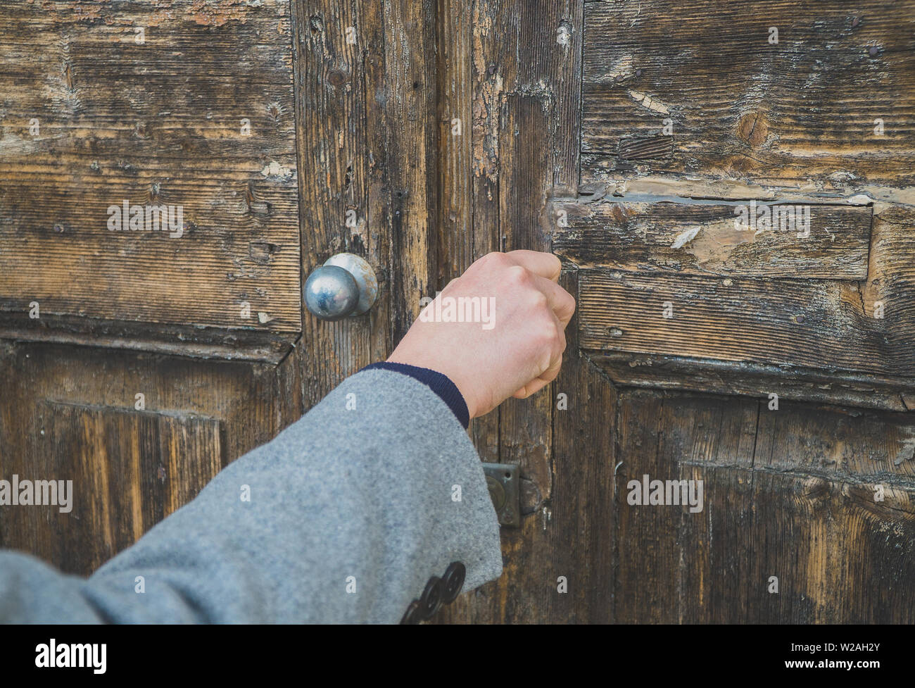 Apertura di una donna molto vecchia porta di legno nella casa. Foto Stock
