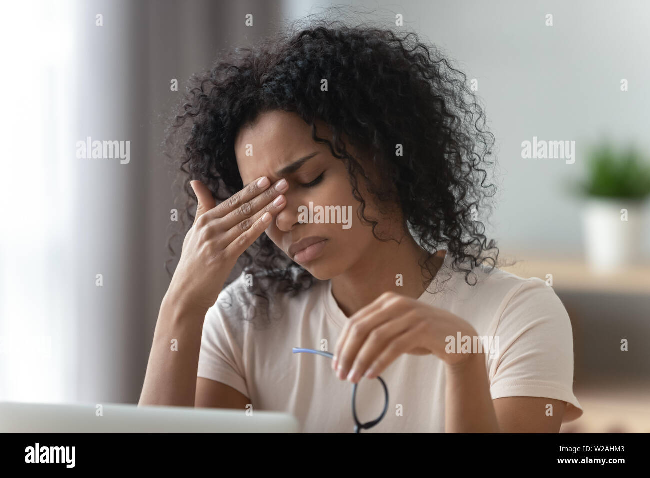 Stanco ha sottolineato giovane donna africana sento mal di testa o affaticamento della vista Foto Stock