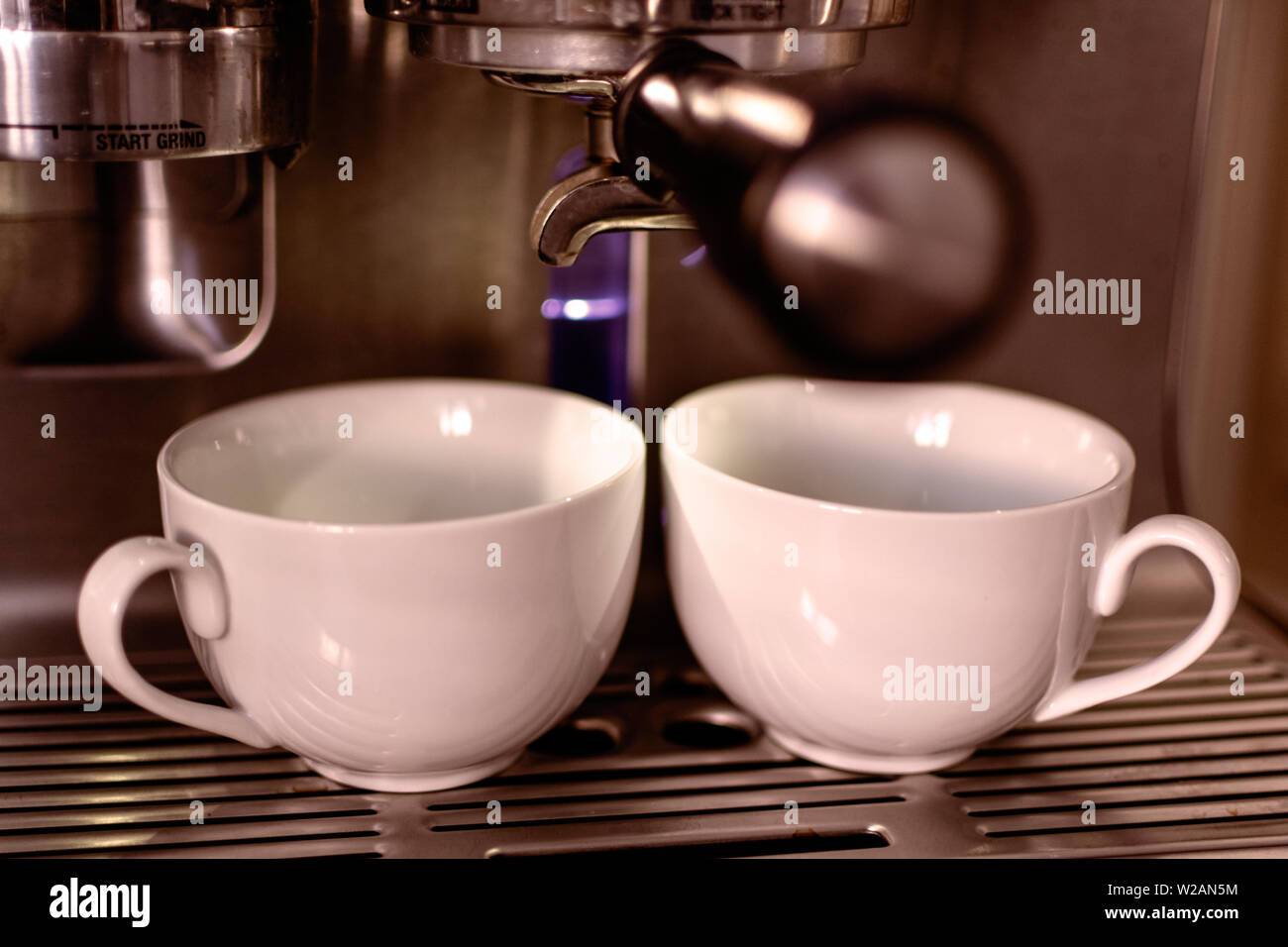 Macchina espresso l'estrazione di caffè in due tazze cappuccino Foto Stock