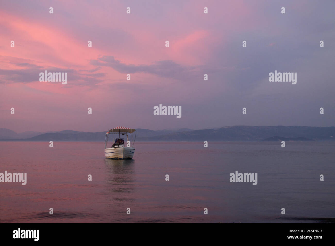 Barca da pesca sulla spiaggia durante il bellissimo tramonto con arancia e colori rosa con copyspace Foto Stock