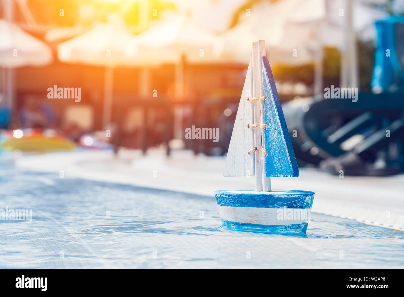 Giocattolo di legno barca a vela presso la piscina nel periodo estivo. Vacanze e tempo libero concetto concetto. Foto Stock