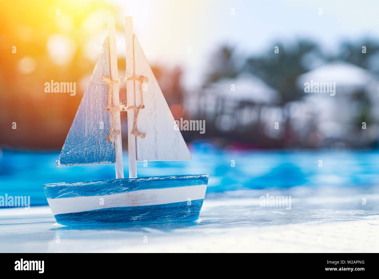 Giocattolo di legno barca a vela presso la piscina nel periodo estivo. Vacanze e tempo libero concetto concetto. Foto Stock