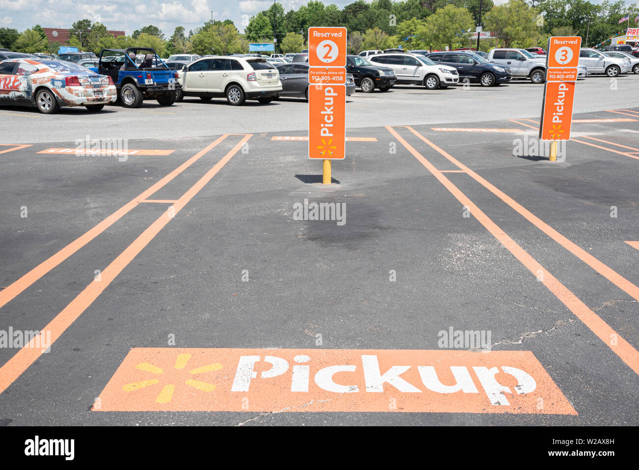 Vidalia, Georgia / STATI UNITI D'America - 28 Maggio 2019: i posti auto riservati per Walmart del nuovo servizio di prelievo sono contrassegnati con importanti segni di colore arancione. Foto Stock